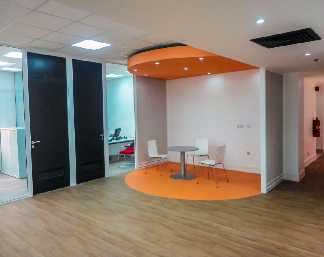 La combinación de los pisos en rollo con los pisos LVT, logra esta combinación armoniosa donde el color naranja resalta en el espacio en la proporción adecuada.